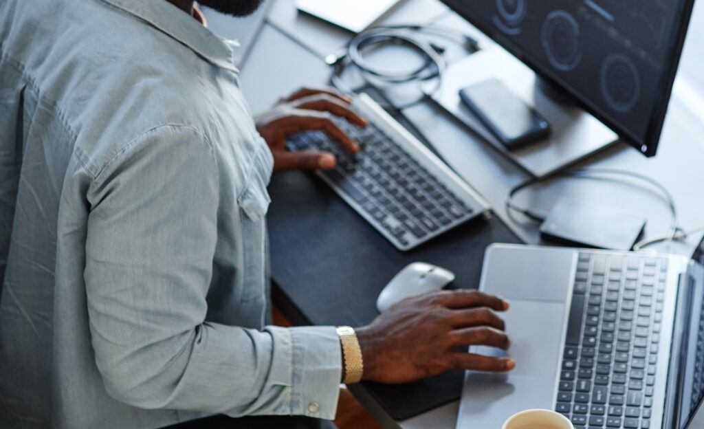 Office worker reviewing financial paperwork beside a laptop
